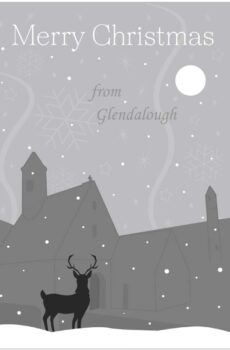 Front cover of Christmas card saying 'Merry Christmas' at the top and 'from Glendalough' at the bottom. Silhouette of Glendalough (Wicklow, Ireland) Round Tower and Church in light blue with navy background for the sky and a white moon. Faded stars and snowflake shapes in the sky too.